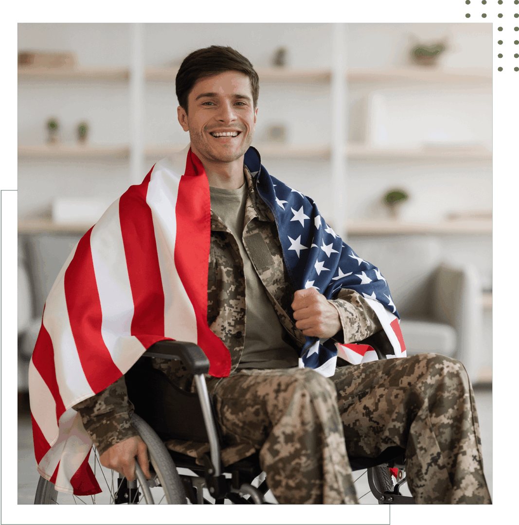 Smiling soldier in wheelchair with American flag.